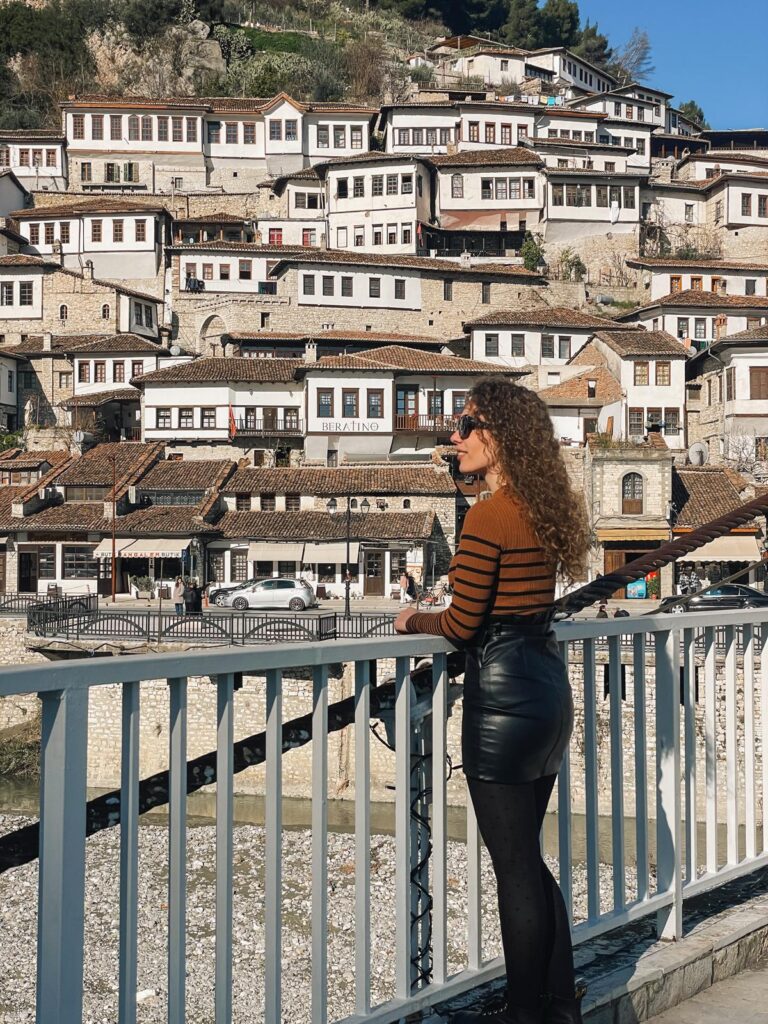 A local standing in Berat during winter with historic buildings in the background and a quiet seasonal feel. The image helps readers visualize what daily life looks like when visiting Albania in winter.