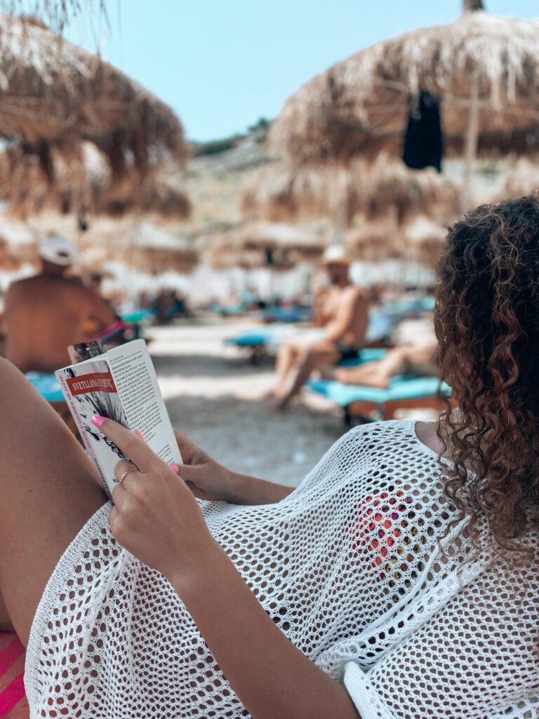 A woman standing on Llamani Beach during a girls trip with the sea and cliffs behind her. The photo adds a personal perspective to the question Is Albania Safe for Solo Female Travelers by showing a relaxed and confident travel moment.