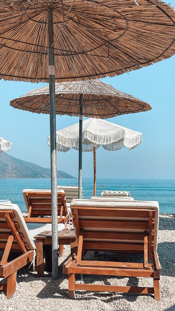 Quiet and empty sandy beach at Orikumi in Vlore with gentle waves lapping the shore and a few scattered rocks. The peaceful, open shoreline offers a serene environment for digital nomads in Albania.
