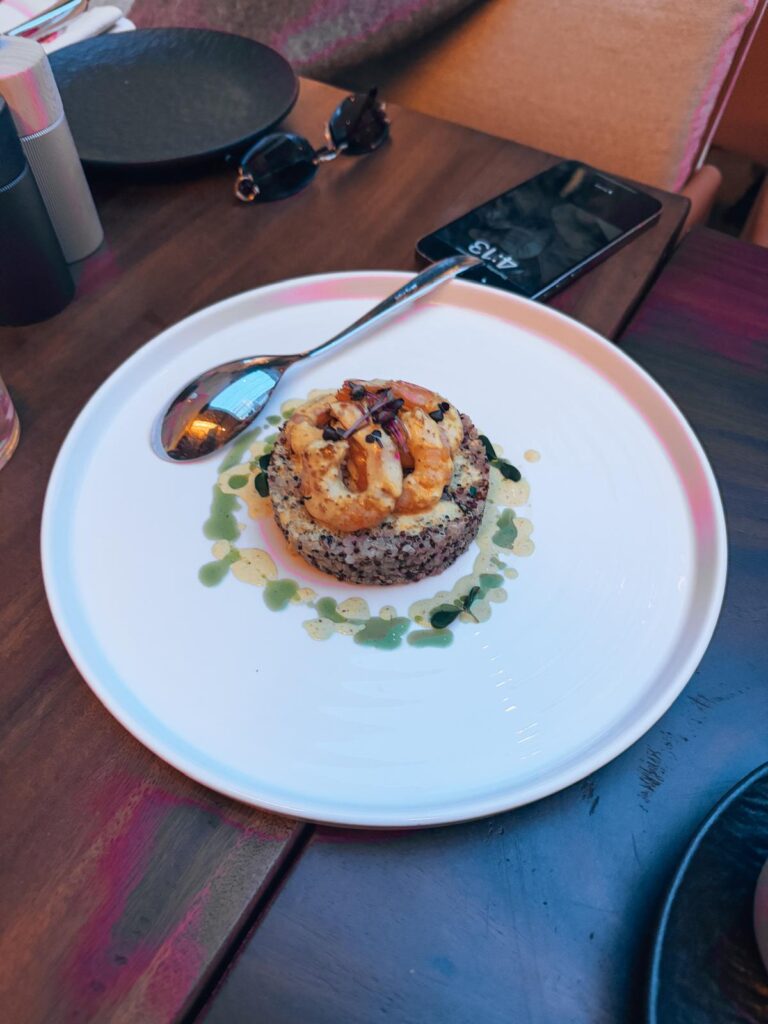 Elegant fine dining setting in Tirana with beautifully plated dishes on a candlelit table and modern decor in the background. Experiencing upscale cuisine is one of the refined things to do in Tirana for visitors exploring the city’s food scene.