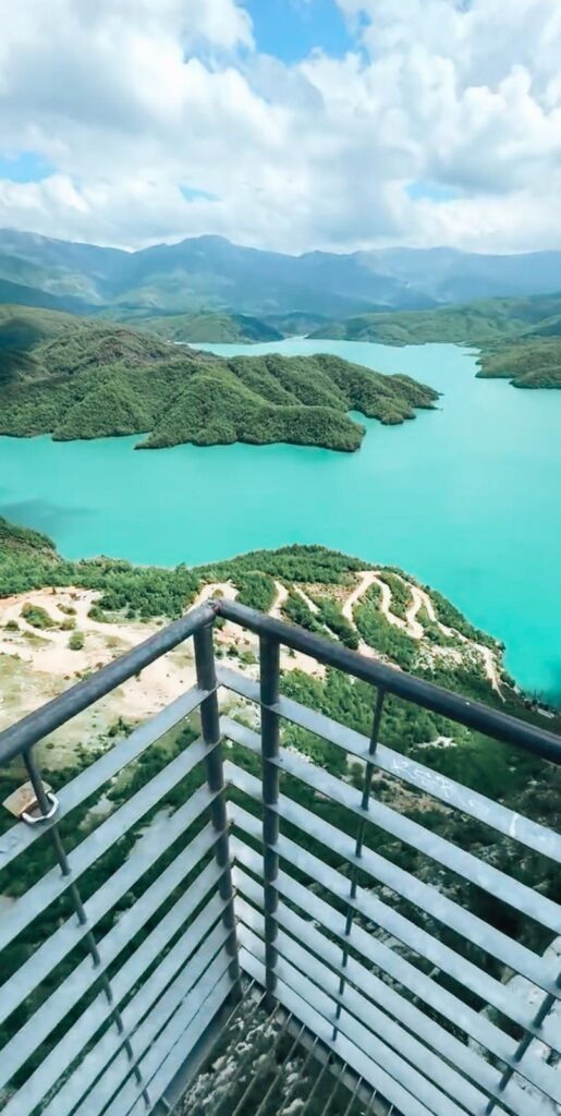 Panoramic view from a lookout platform showing Lake Bovilla’s bright turquoise water winding through steep rocky cliffs under a clear sky.