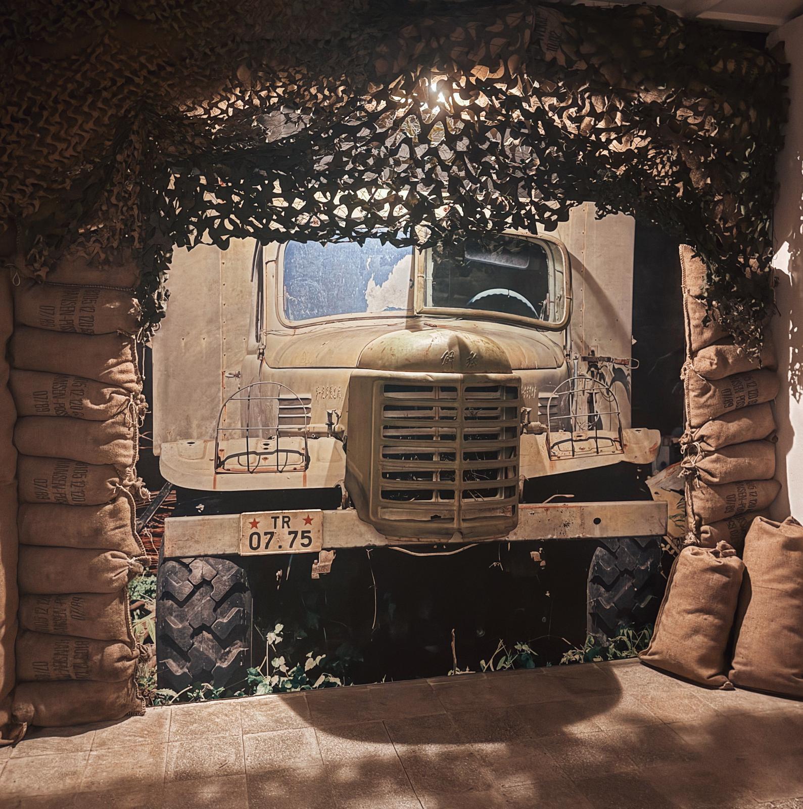 An old truck with a large, boxy body sits weathered and worn, showing signs of heavy use and age from the communist era. The vehicle adds to the atmosphere encountered when visiting a bunker in Albania and exploring remnants of the past.