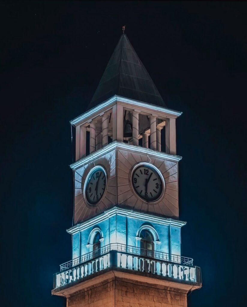 Elegant rooftop terrace of a hotel in Tirana with panoramic night views over the city skyline and distant hills glowing with soft lights. The scene aligns with “best hotels in Tirana,” highlighting a premium stay experience with a calm, elevated atmosphere overlooking the urban landscape.