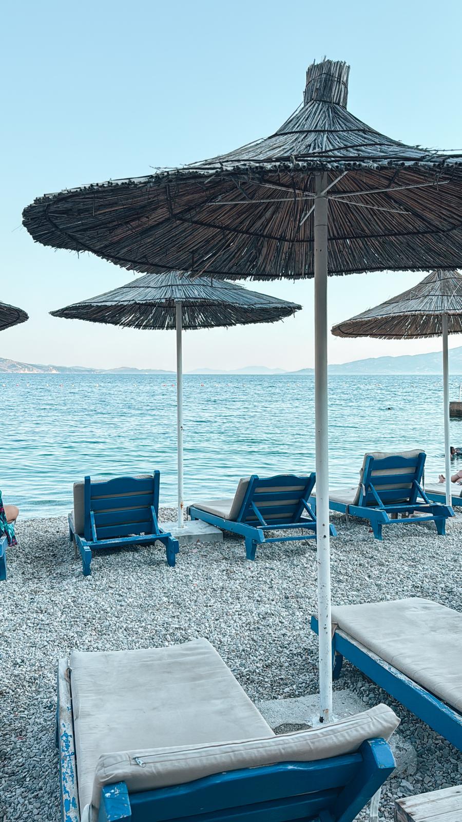 Alt text: Orikumi Beach in Albania with calm blue water, a wide shoreline, and mountain views stretching along the coast. The relaxed atmosphere and scenic Riviera setting make Orikumi one of the best beaches in Albania for a quiet seaside escape.