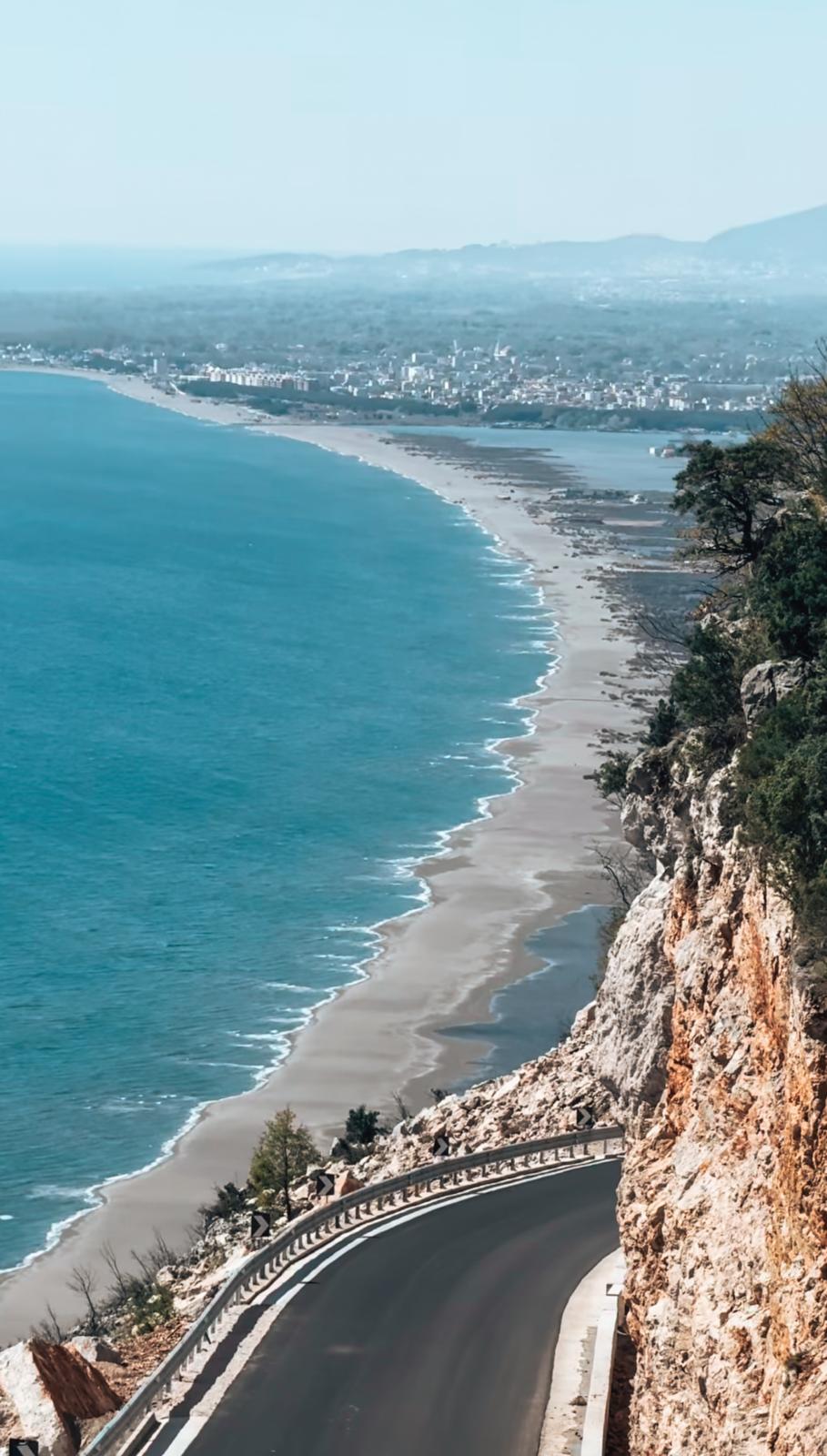 Velipoja Beach in Albania with a very wide sandy shoreline meeting shallow Adriatic waters and a flat coastal landscape extending toward distant dunes. The spacious, natural setting makes it one of the best beaches in Albania for long walks and relaxed seaside days.