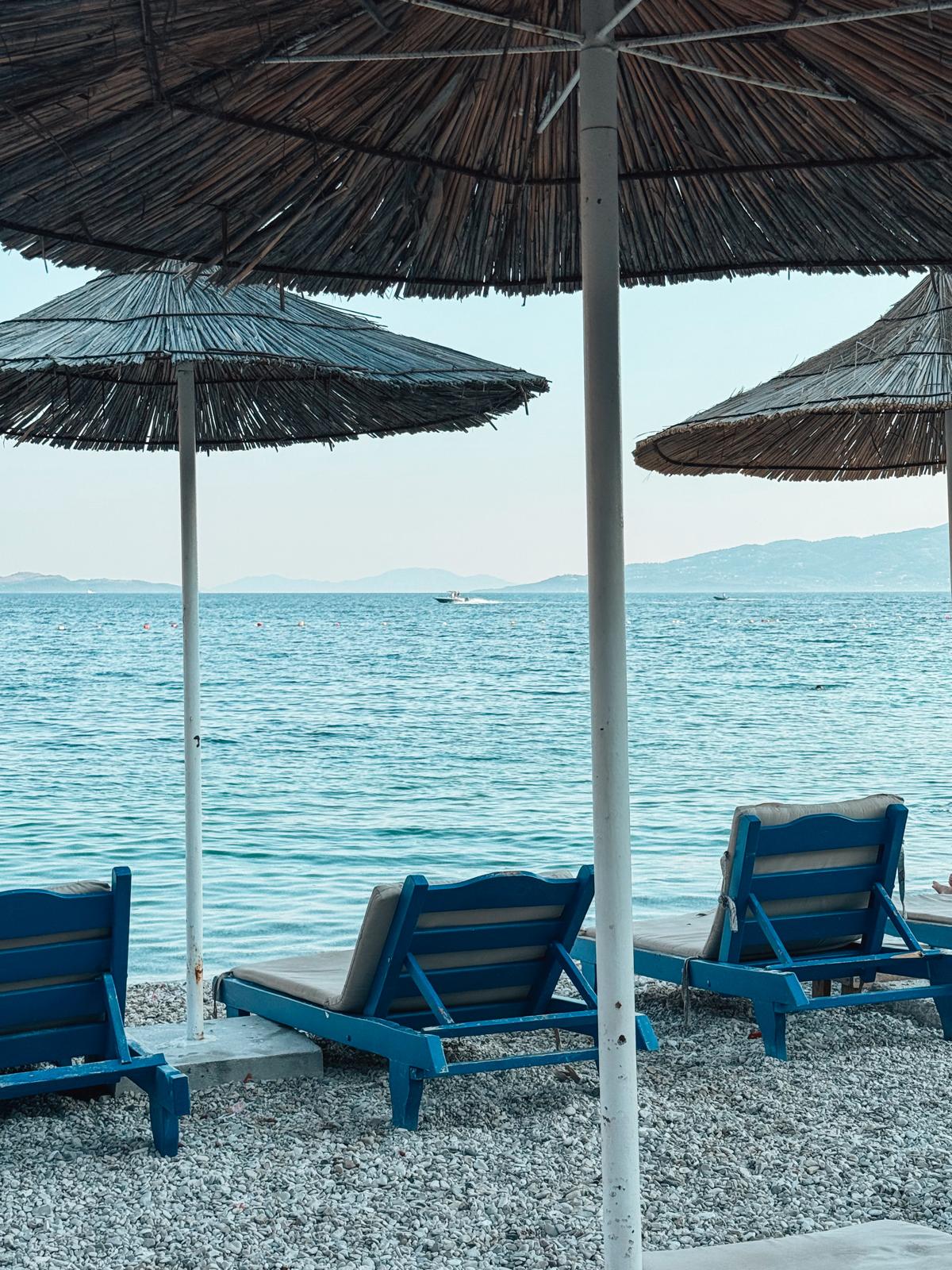 Wide view of Saranda Beach with clear turquoise water and visitors relaxing along the shoreline. The beach showcases the coastal scenery featured in this guide to Saranda’s beaches.