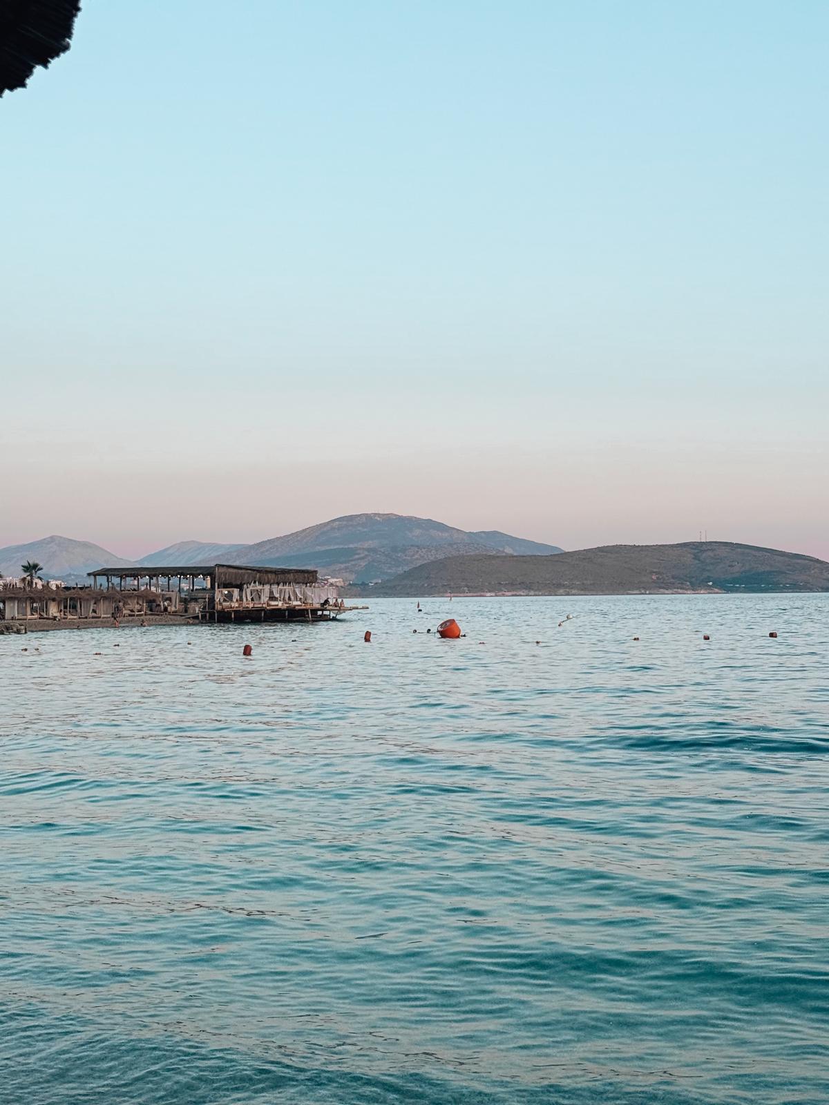Panoramic view of the Ionian Sea with crystal clear water extending toward the horizon. The scenery captures the natural beauty that draws visitors to Saranda's coastline.