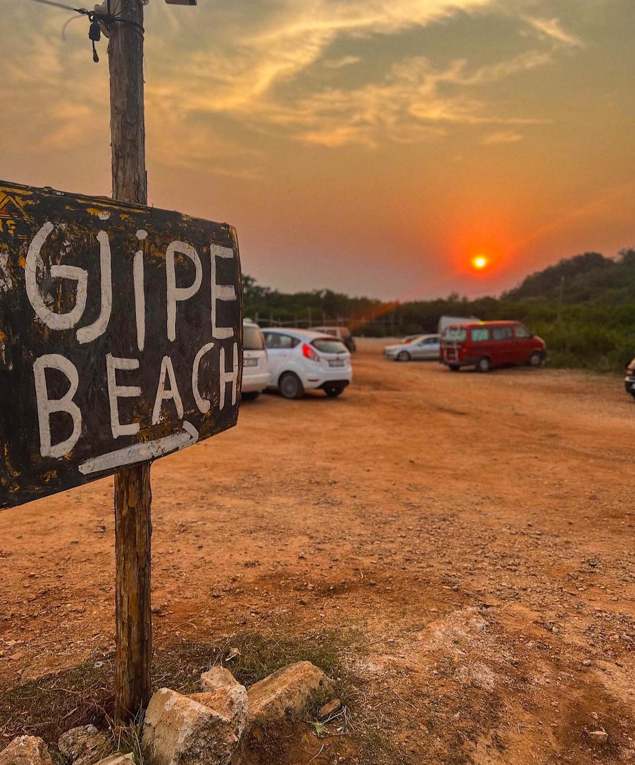 Parking area near the entrance to the trail leading down to Gjipe Beach. Cars are parked beside the rugged coastal landscape where visitors begin the walk to Gjipe Beach from Himarë.