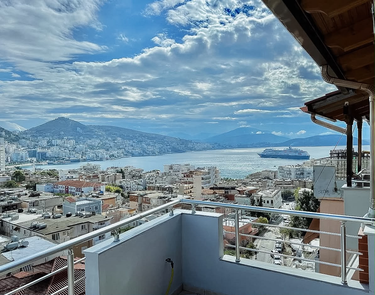 Apartment perched on a hillside in Saranda with a wide view overlooking the city, the coastline, and the Ionian Sea. This perspective shows what guests can expect from a hillside stay, making it a helpful example for travelers researching where to stay in Saranda.