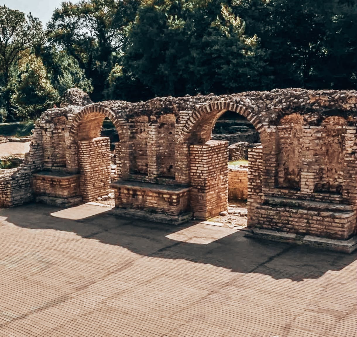 Final view of ruins in Butrint National Park with scattered stone structures and overgrown areas. The combination of nature and ancient architecture highlights the site’s long history and preserved archaeological character.