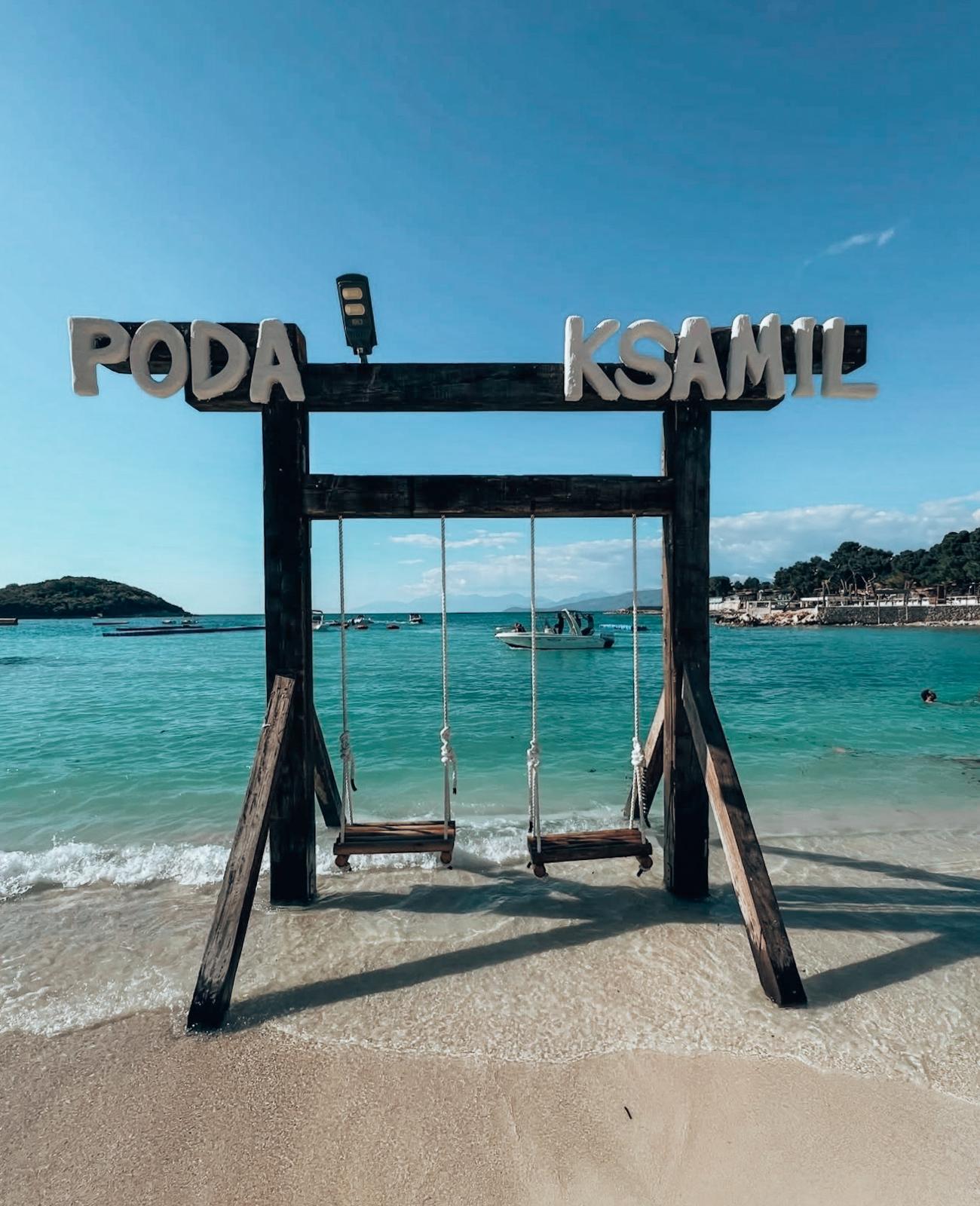 Swing at Pogoda Beach in Ksamil overlooking the turquoise sea and sandy coastline. A scenic beach spot that shows the relaxed atmosphere visitors can enjoy when comparing Ksamil vs Saranda where to stay.