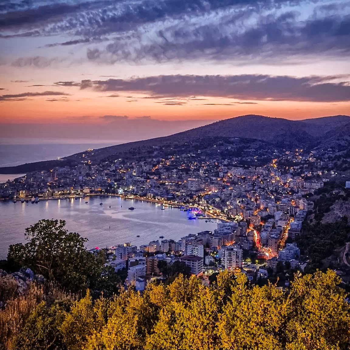 Rolling green hills surrounding Saranda with panoramic views stretching across the landscape. The scenery highlights the peaceful setting beyond the waterfront and offers a glimpse of the natural surroundings for travelers deciding where to stay in Saranda.